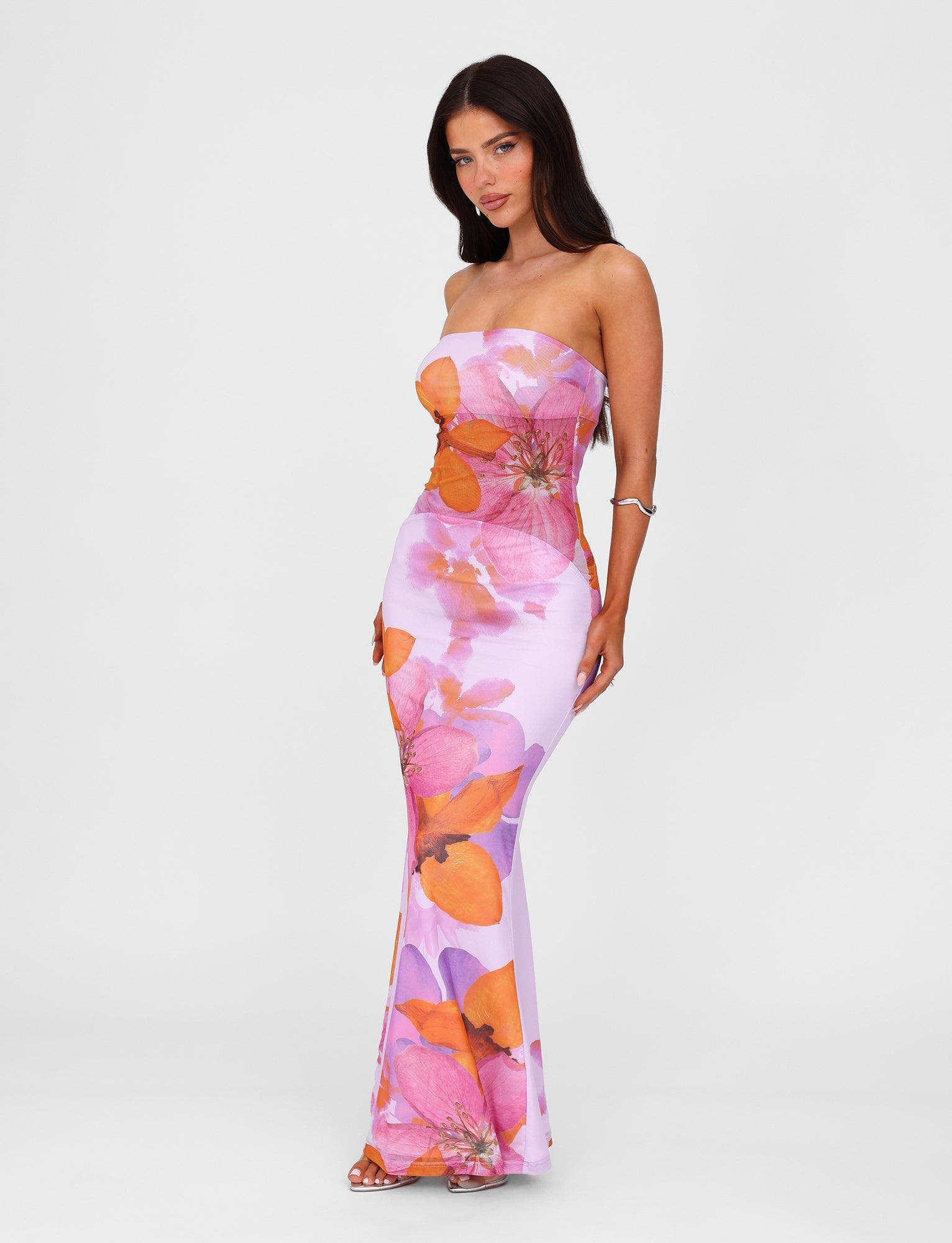 Front view of a strapless Valeria maxi dress in a vibrant pink and orange floral pattern, on a light background.