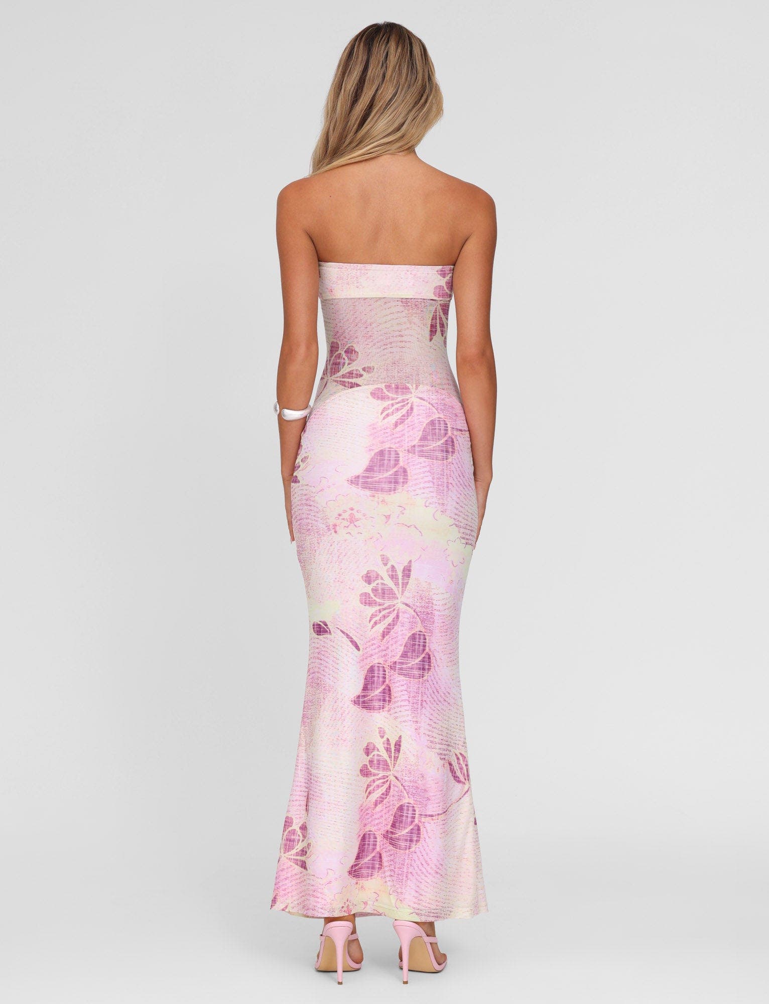 Back view of a light pink and purple floral strapless Valeria maxi dress, showing the fitted silhouette.