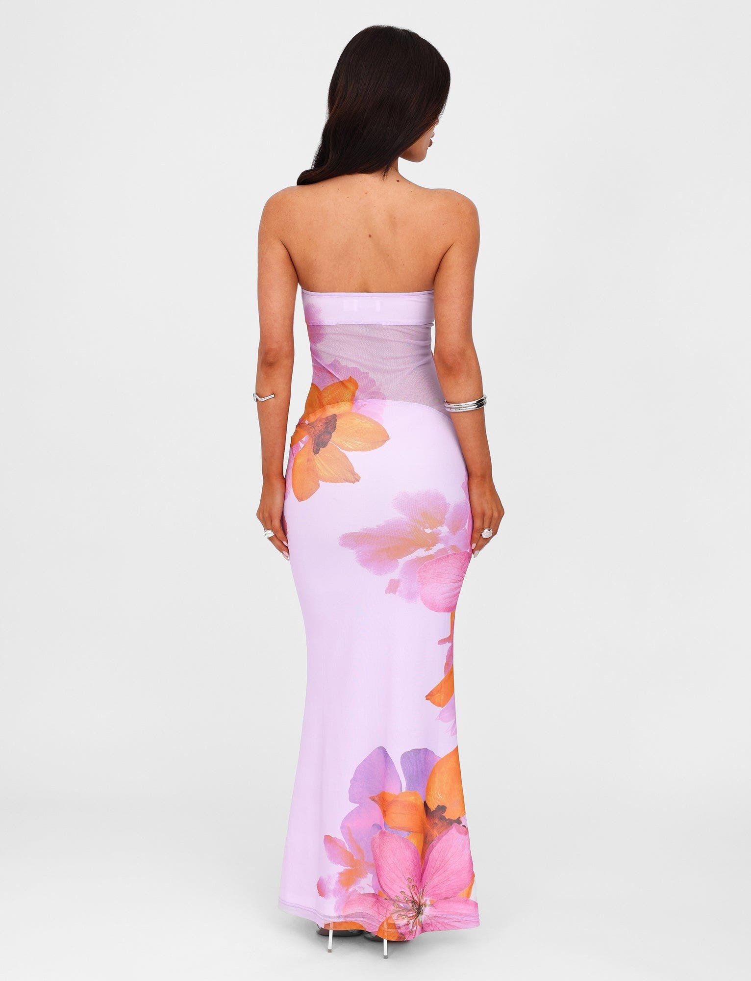 Rear view of a strapless Valeria maxi dress in a pink and orange floral pattern, highlighting the back design.