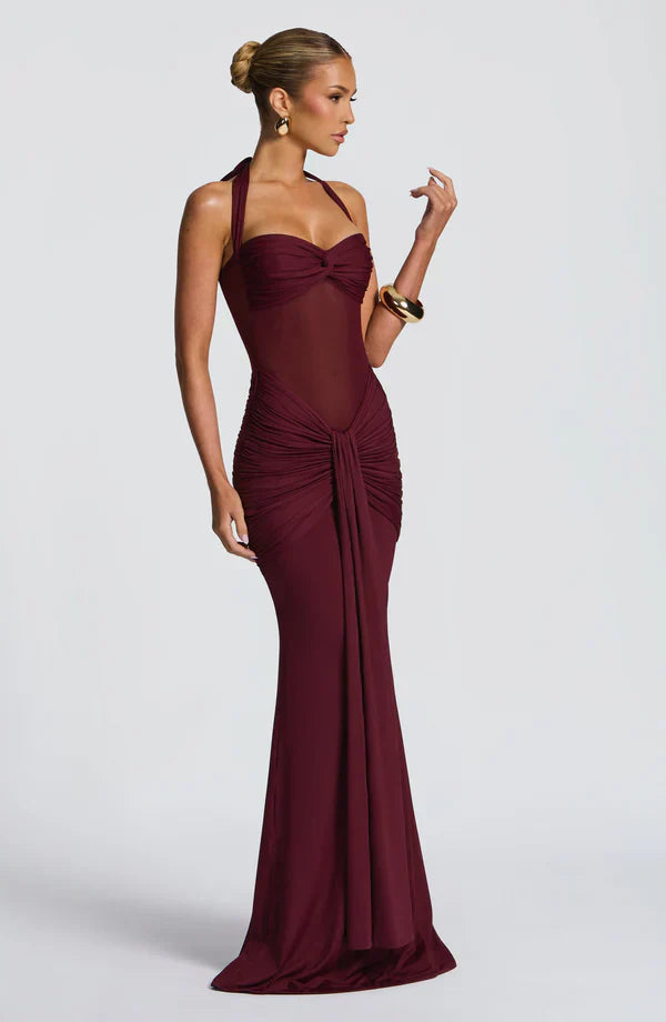 Side profile of the burgundy Victoria ruched maxi dress, highlighting the elegant drape and form-fitting silhouette.
