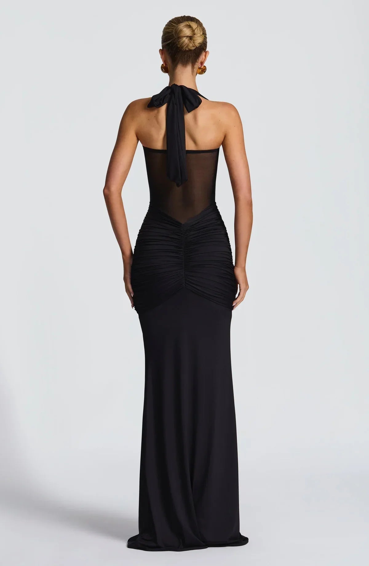 Rear view of the black Victoria ruched maxi dress, showcasing the halter tie and ruched detailing down the back.