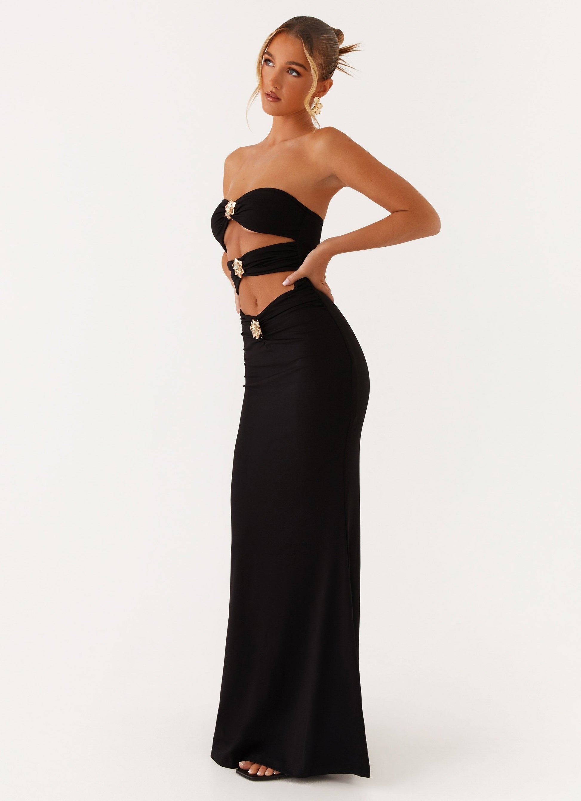 Side profile of the black Vienna Cutout Maxi Dress, showing the elegant cutouts and floor-length design.