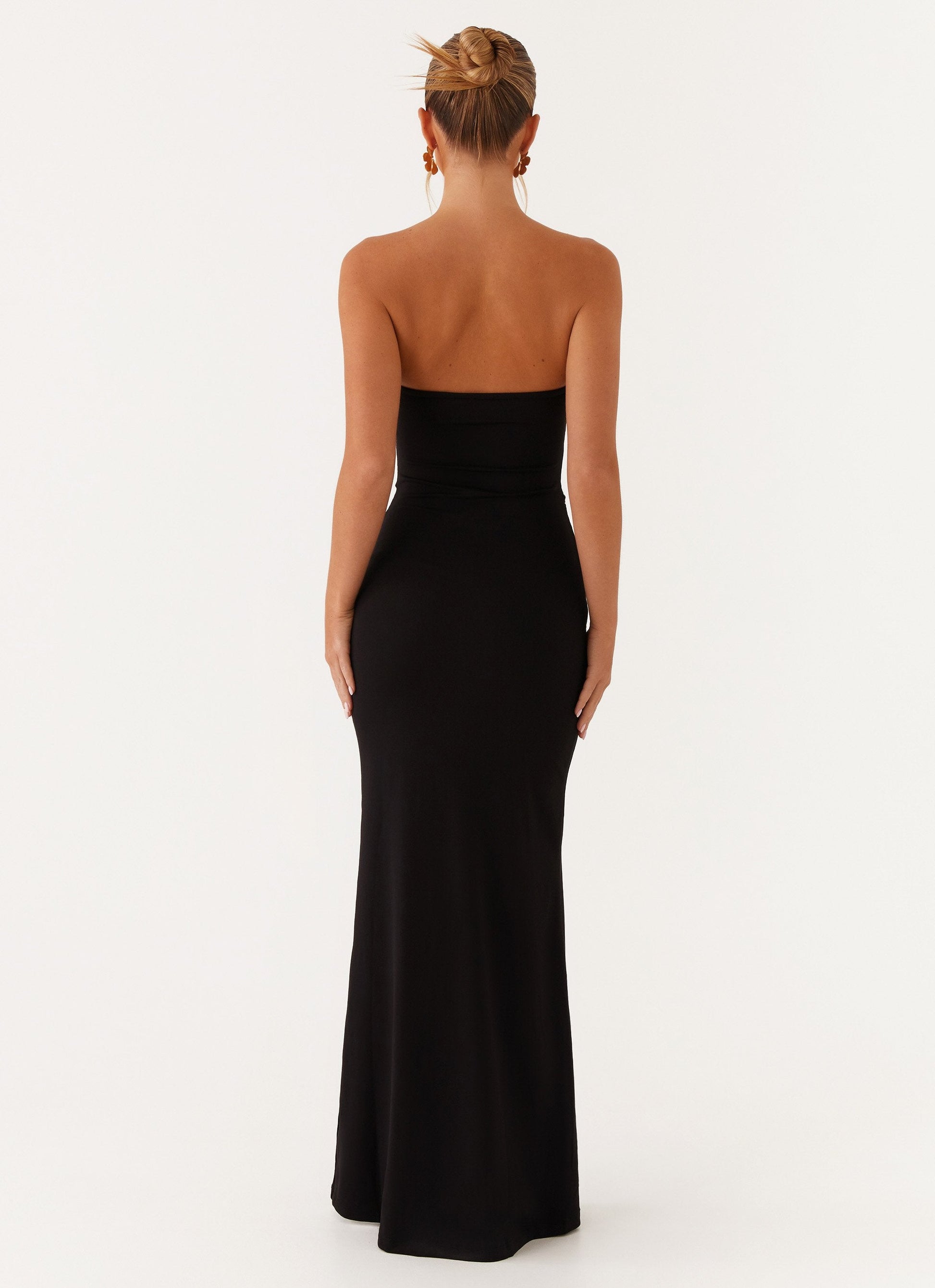 Back view of the black Vienna Cutout Maxi Dress, displaying the smooth, form-fitting fabric and strapless back.