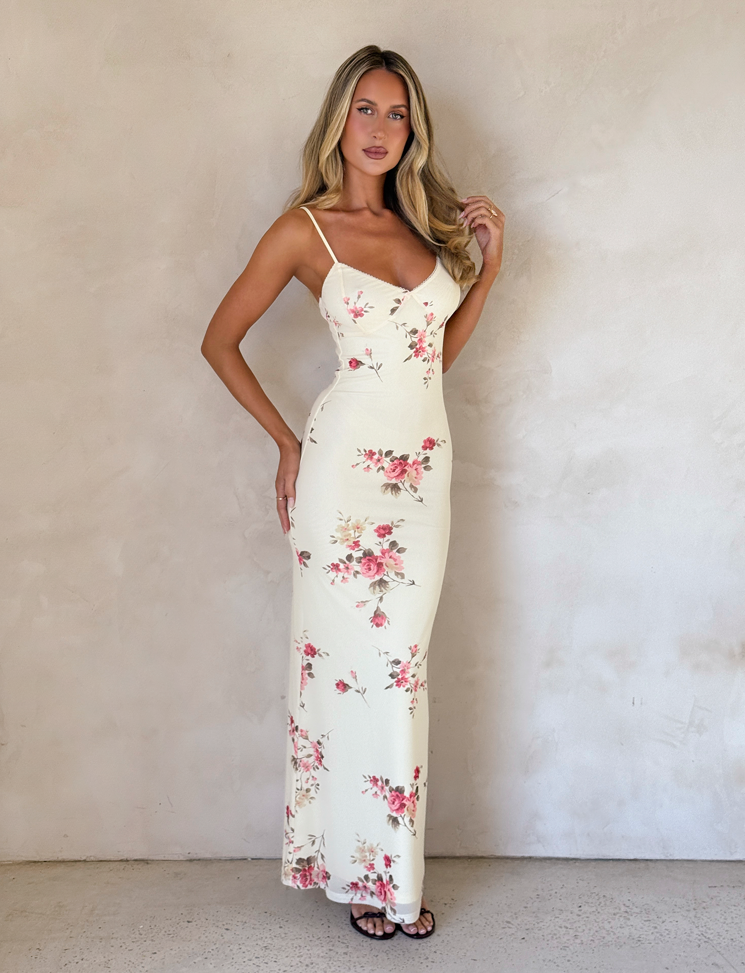 Full-length view of a cream floral maxi dress with pink and red rose patterns, featuring a sweetheart neckline and thin straps.